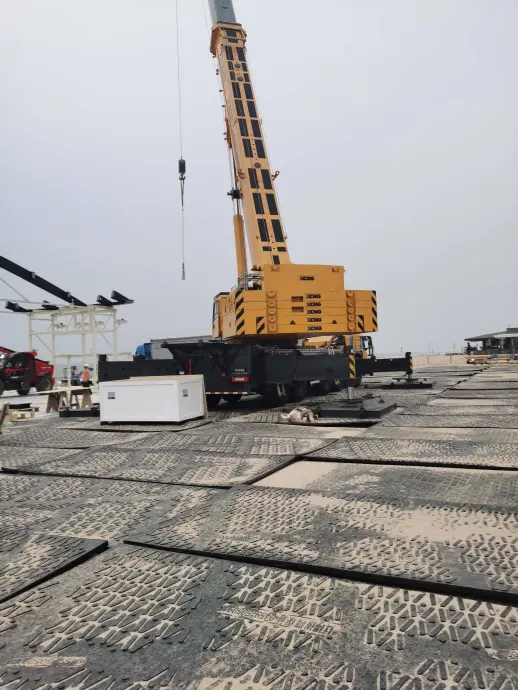 Crane operating on ground protection mats forming a stable access surface on a construction site