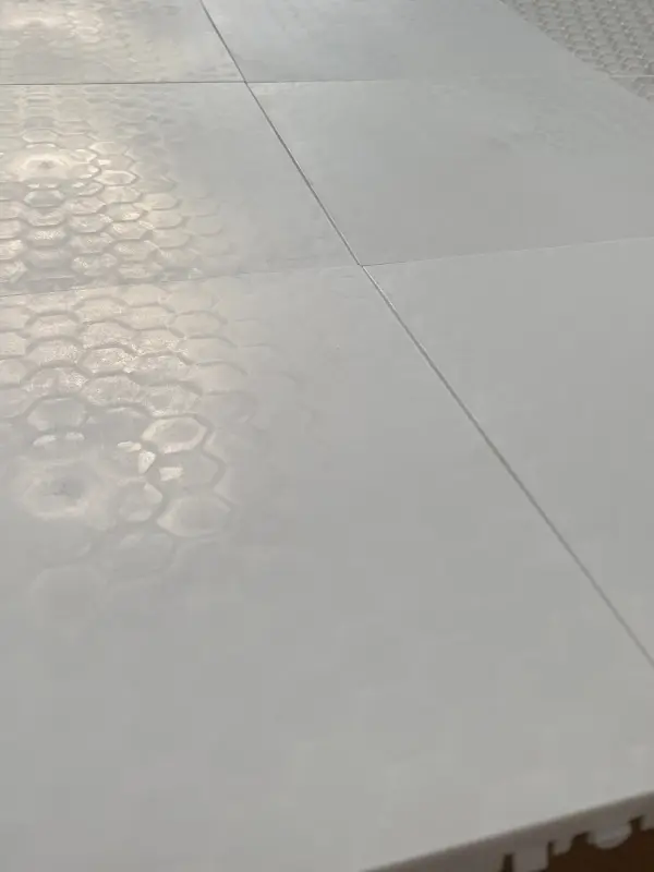 Close-up of modular synthetic ice panels showing interlocking system for fast installation and flexible rink layout.